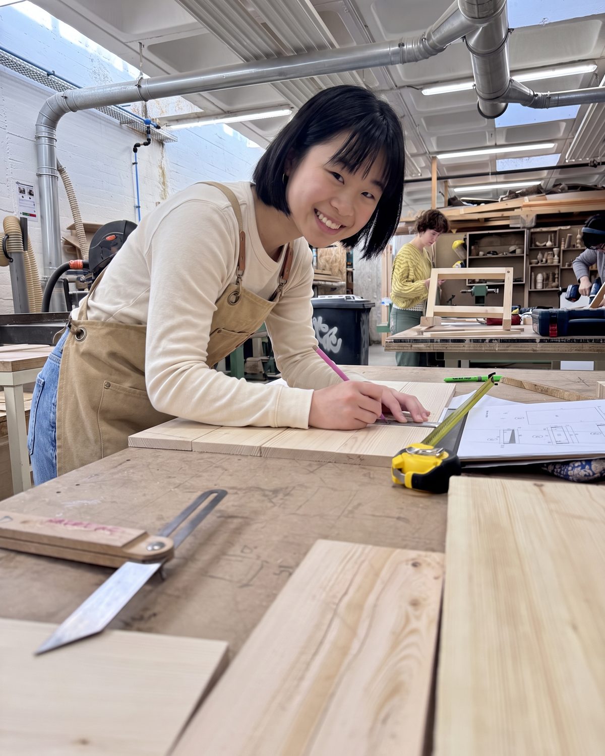 Maya marking a board for a Wondershelf at the workbench